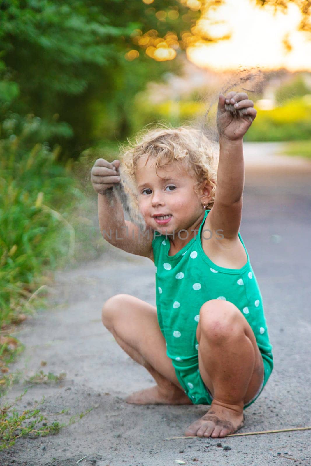 Children play with sand on the street. Selective focus. by yanadjana