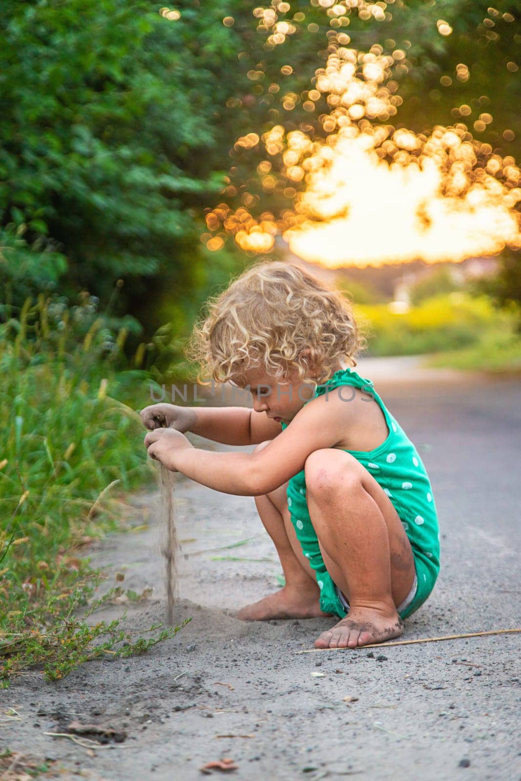 Children play with sand on the street. Selective focus. by yanadjana