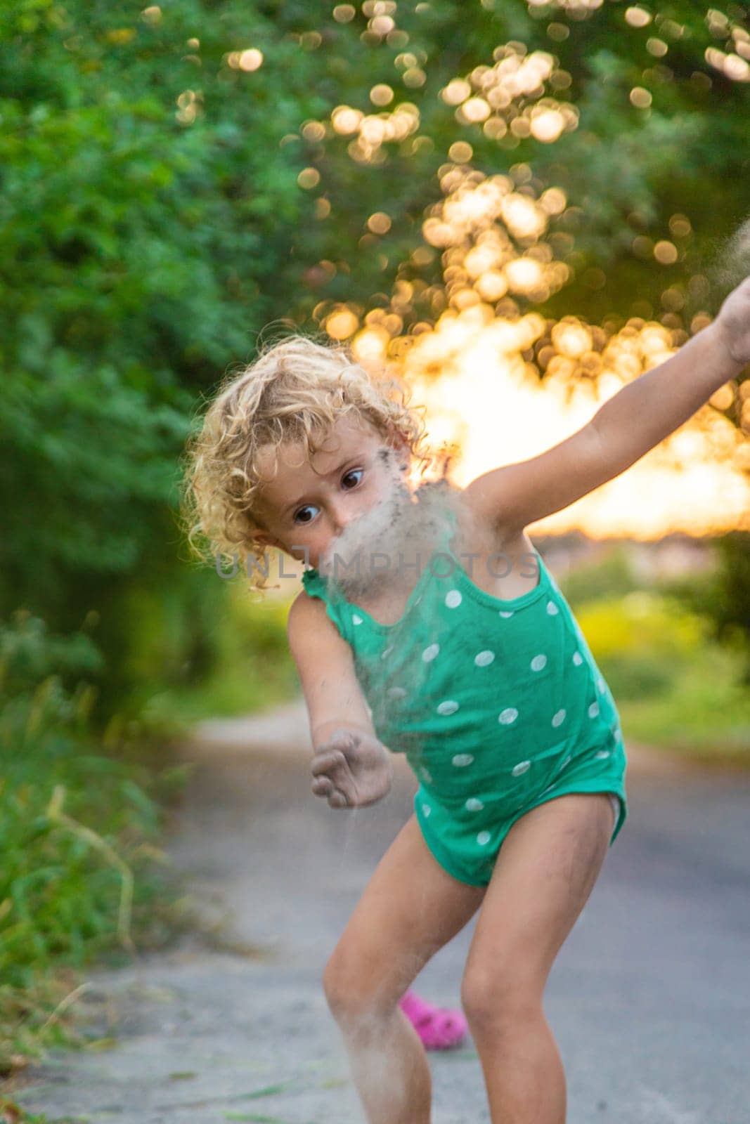 Children play with sand on the street. Selective focus. by yanadjana