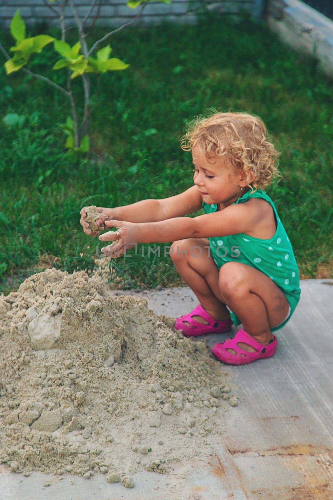 Children play with sand on the street. Selective focus. by yanadjana