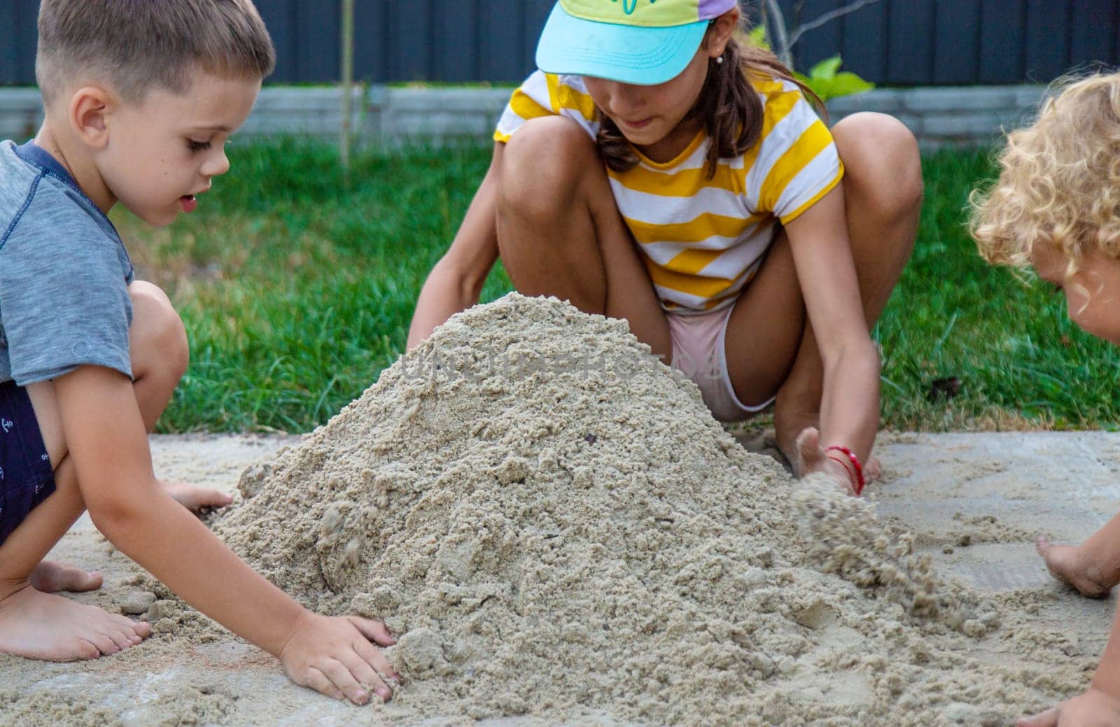 Children play with sand on the street. Selective focus. by yanadjana