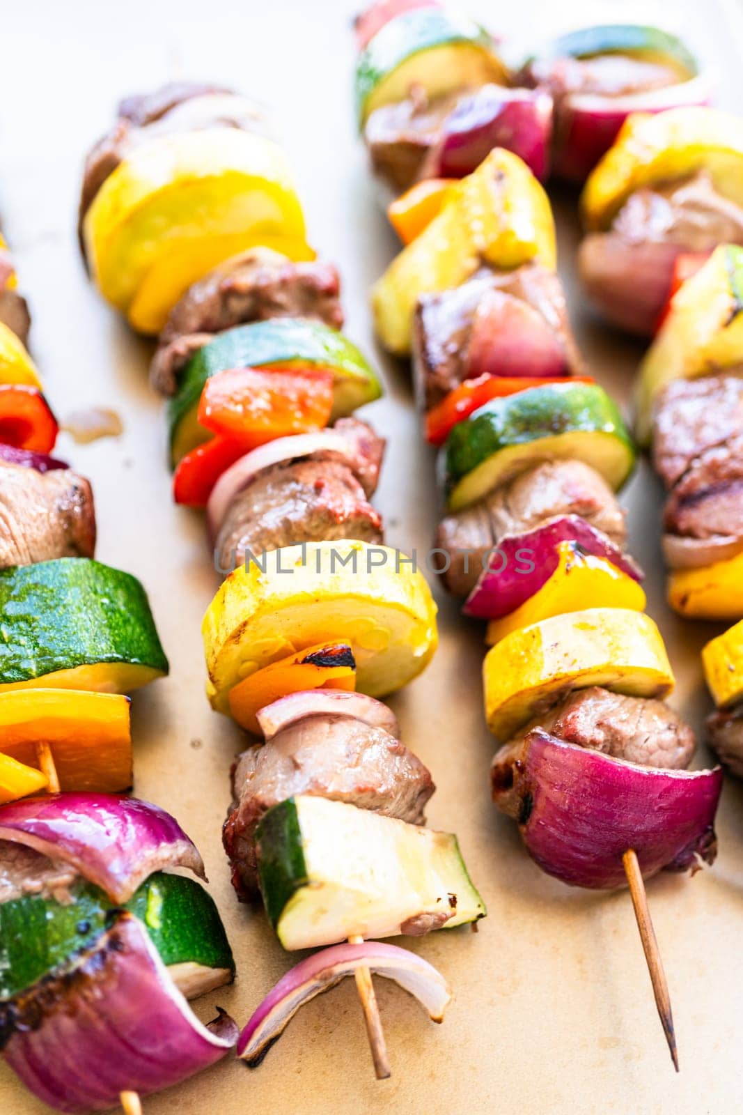 Flavorful beef and colorful veggie skewers, marinated and grilled to perfection, sizzling on a baking sheet.