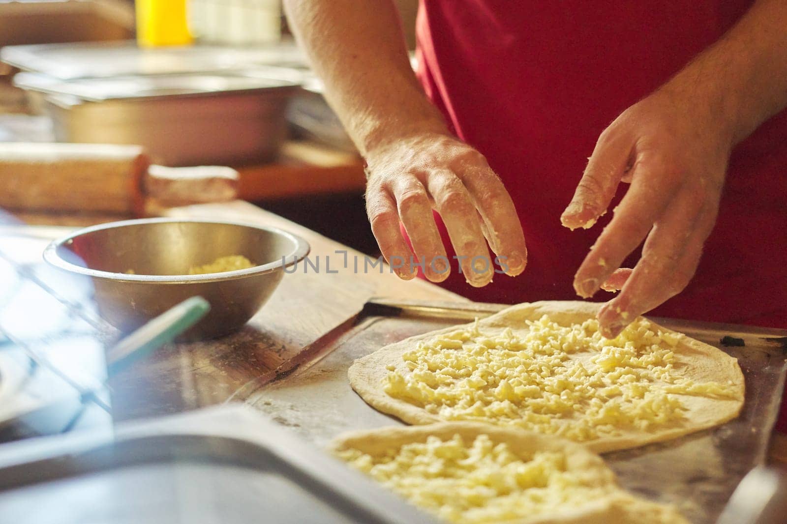 Close-up hands of male baker preparing traditional Georgian cuisine khachapuri by VH-studio