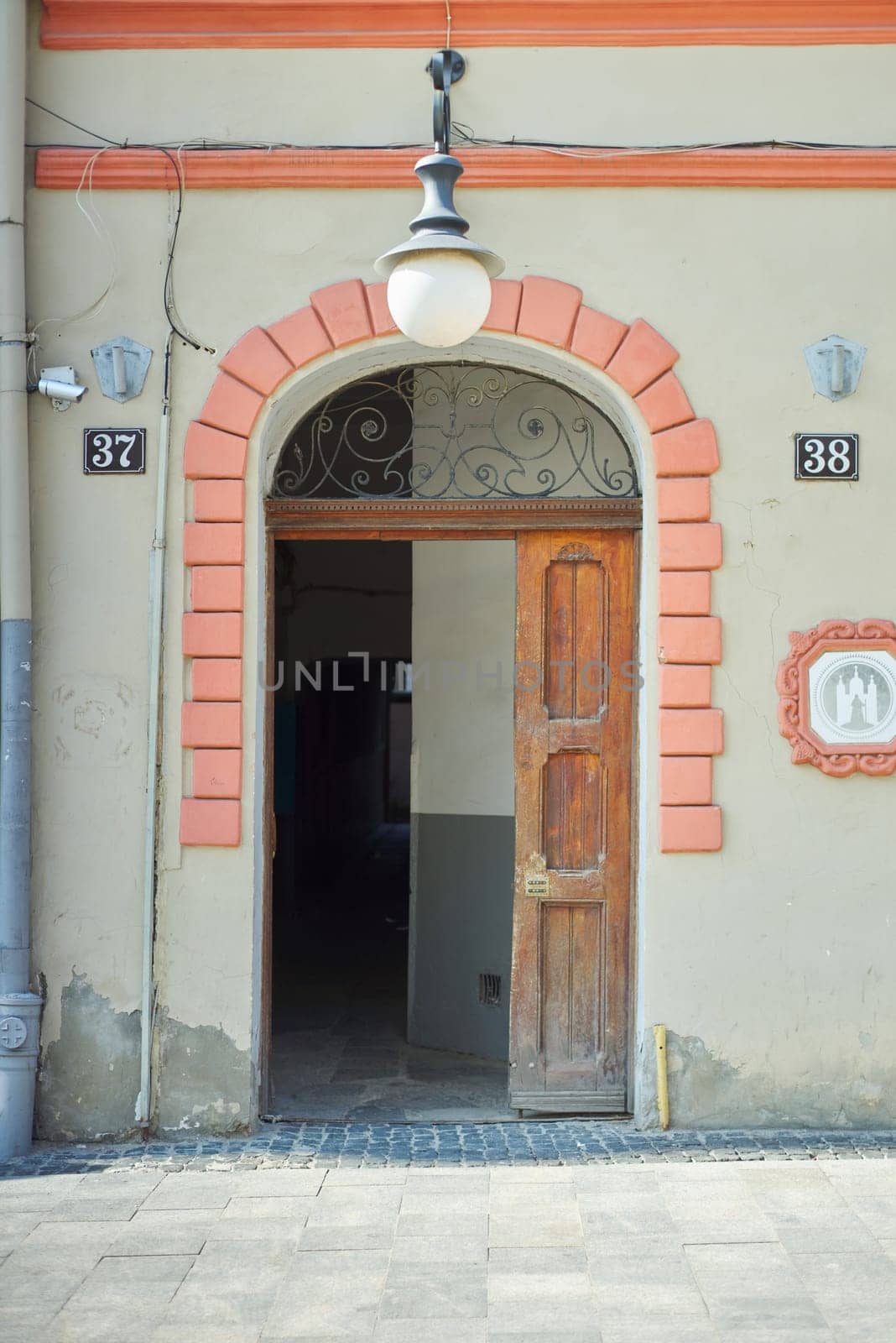 Lviv, UA, 08-08-2019. Facade of old house with open wooden entrance door.
