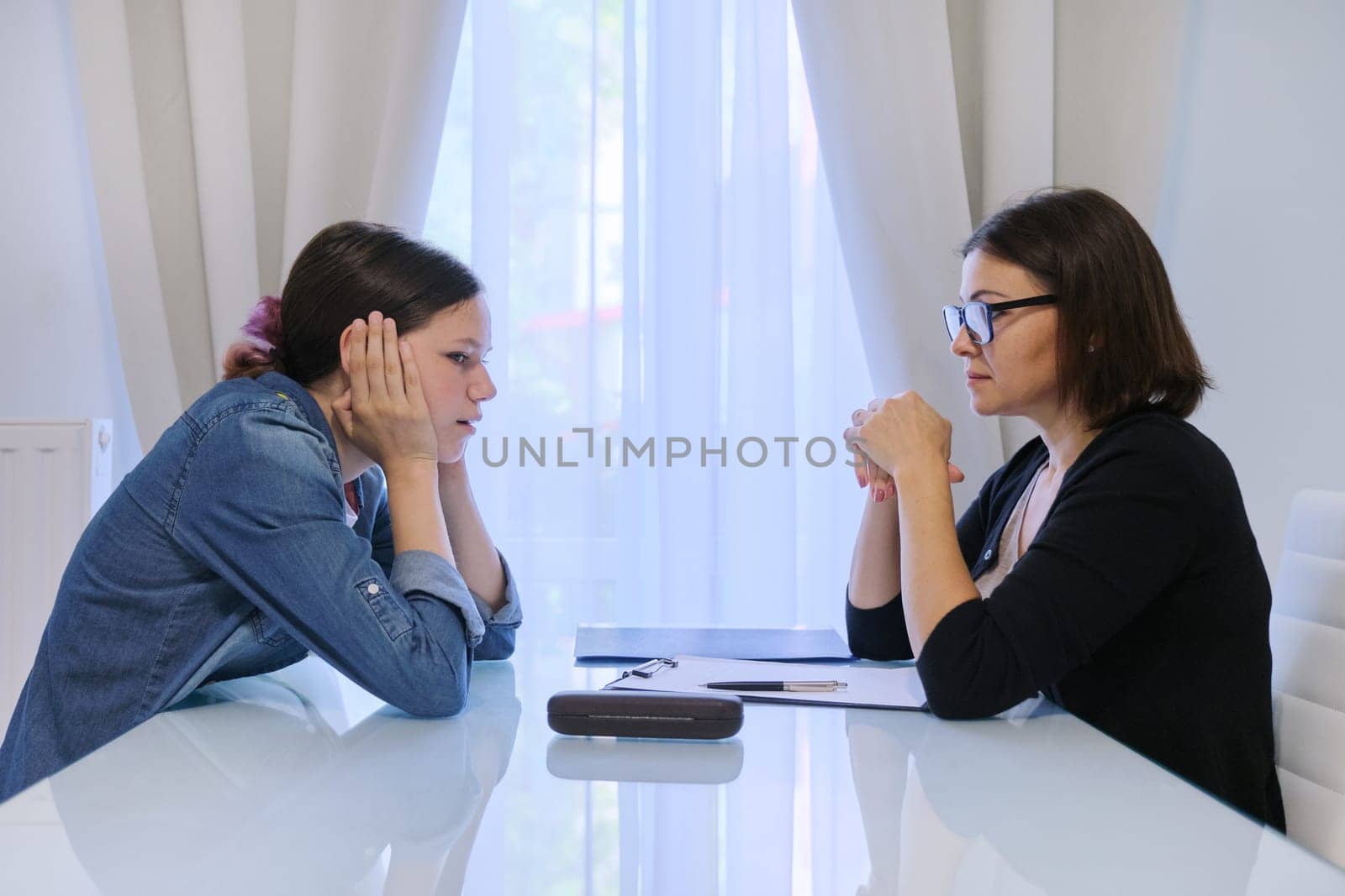 Teenage girl talking with counselor psychologist about her feelings by VH-studio