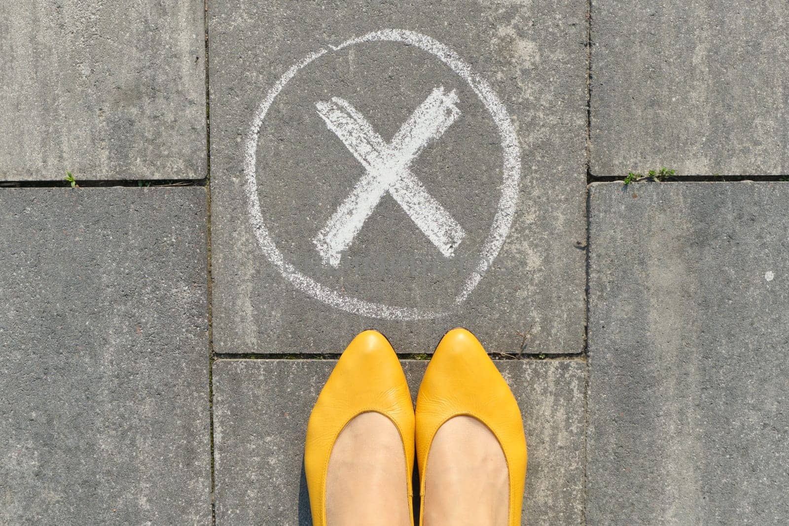 Checkmark no sign on gray sidewalk with woman legs, top view by VH-studio