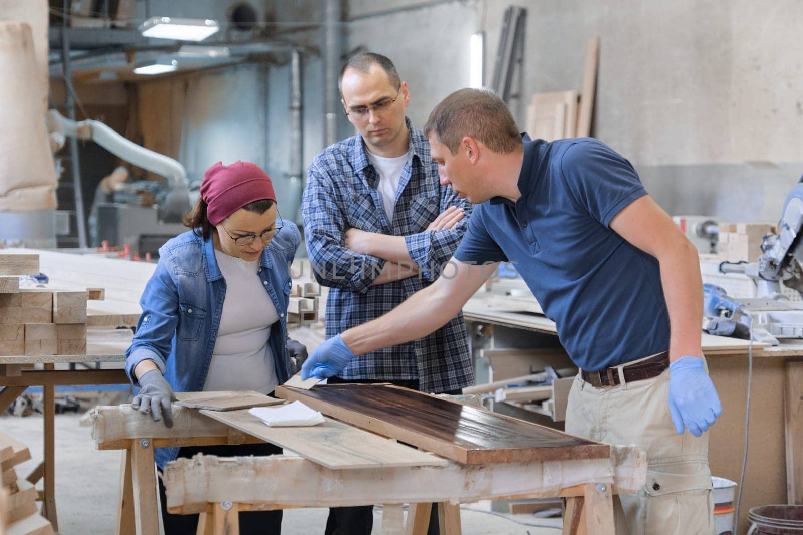 Group of people working in carpentry workshop by VH-studio