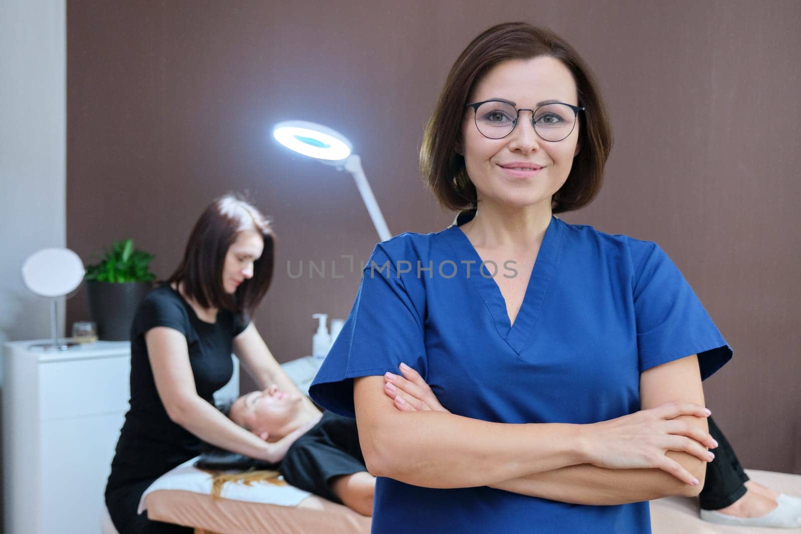 Portrait of woman cosmetologist doctor with crossed arms at beauty clinic. People, spa, cosmetology and skincare concept