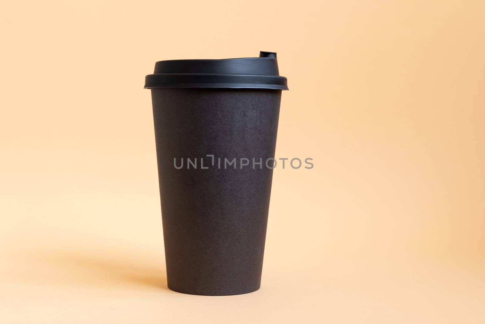 One takeaway black coffee cup on neutral background. Mock-up, nobody, front view, copy space. by Ri6ka
