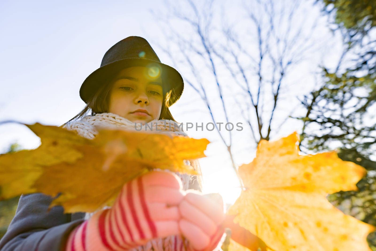 Autumn outdoor portrait of girl with yellow maple leaves by VH-studio