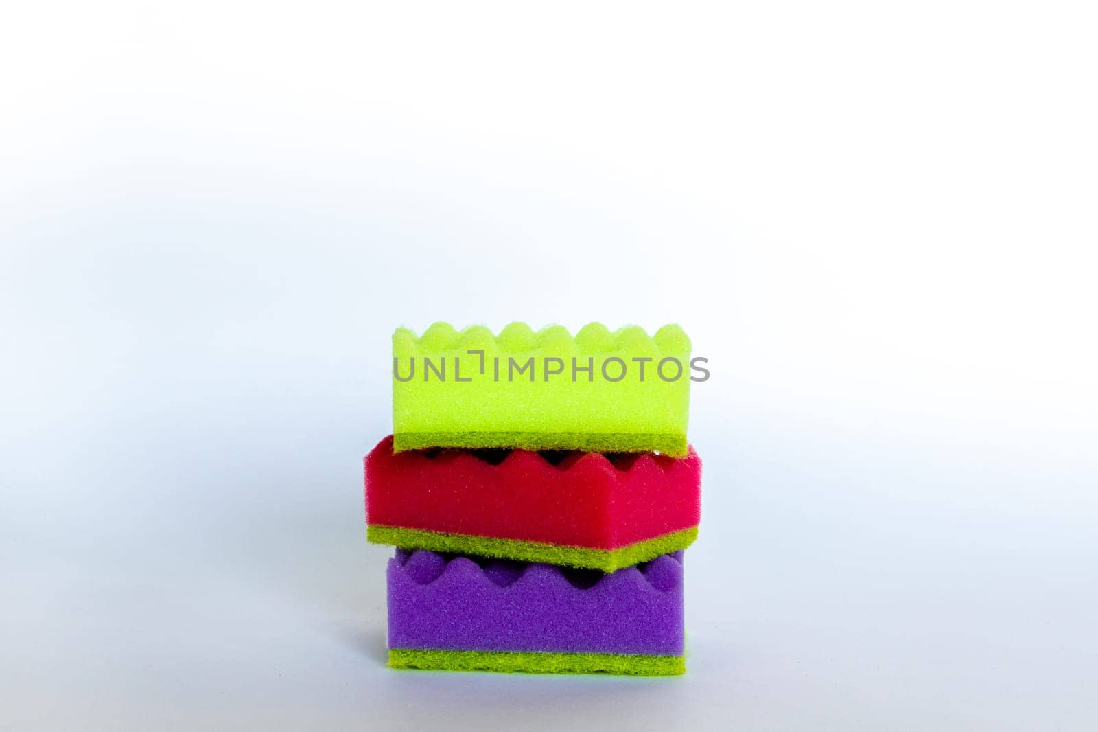 Stack of many multi-colored dish wash sponges. Household cleaning scrub pad. Home cleaning concept. Space for text by Ri6ka