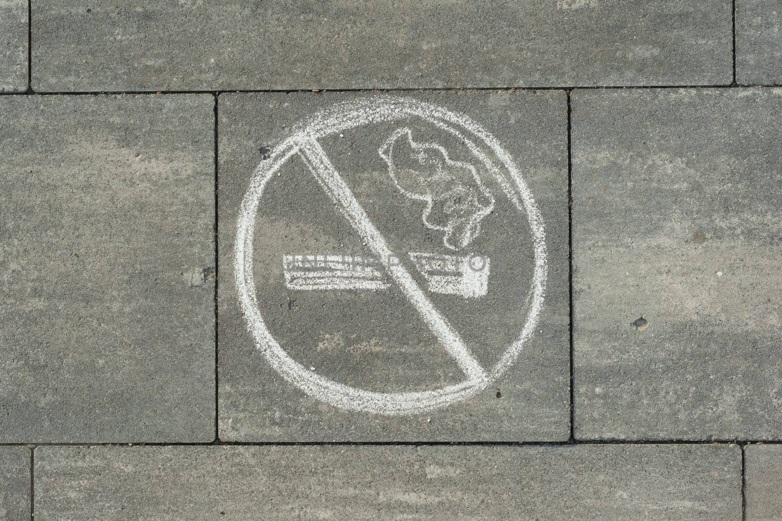 Sign no smoking painted on the grey sidewalk.