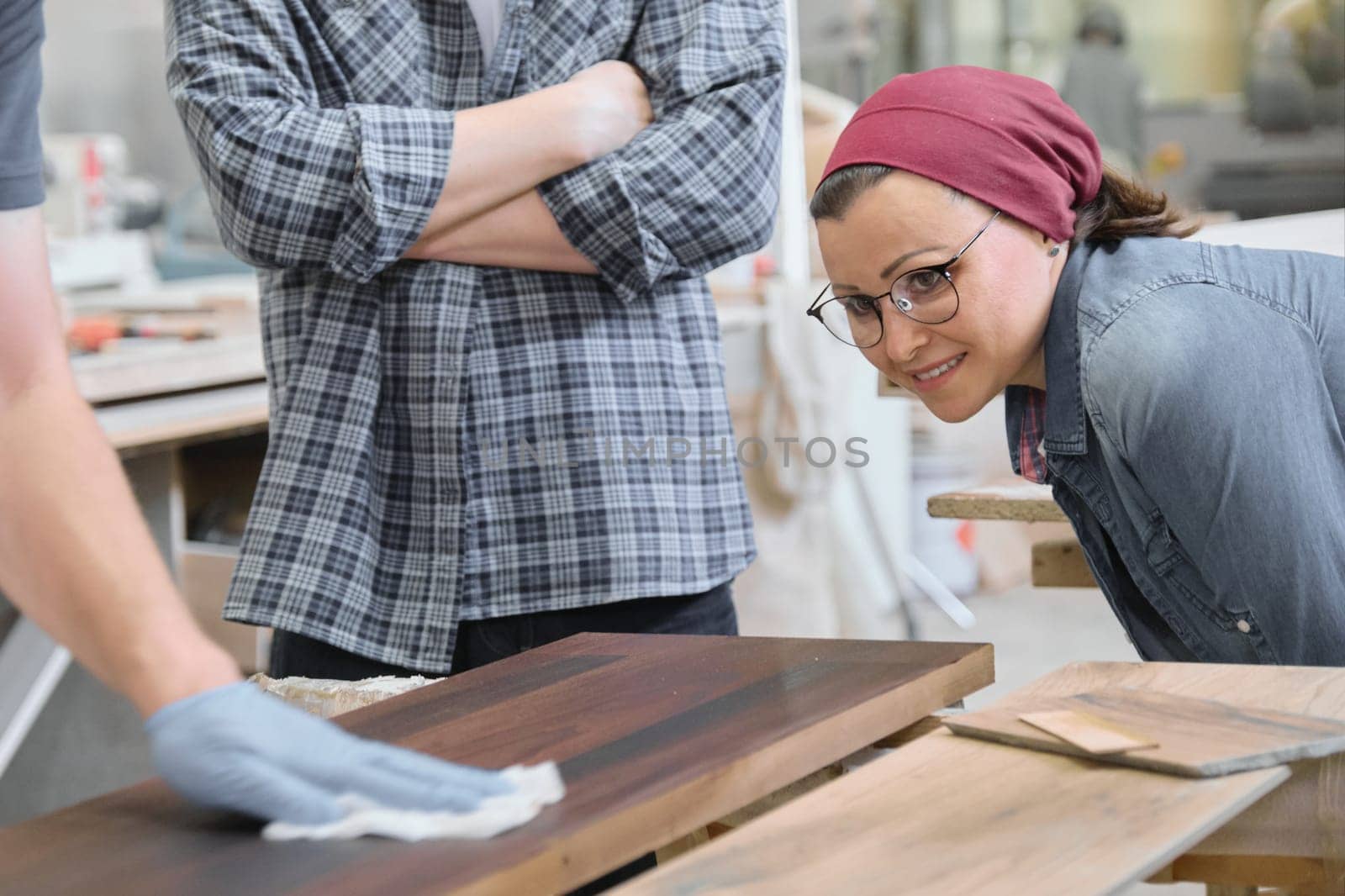 Woodworking workshop, worker varnishing wooden shelf closeup.