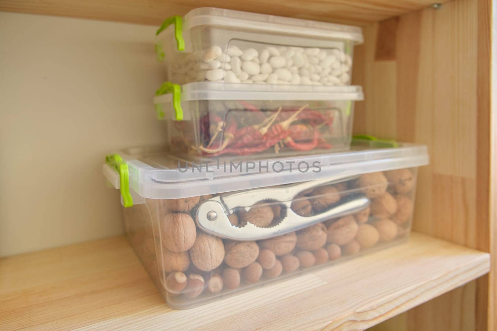 Storage cabinet in kitchen with wooden shelves with food.