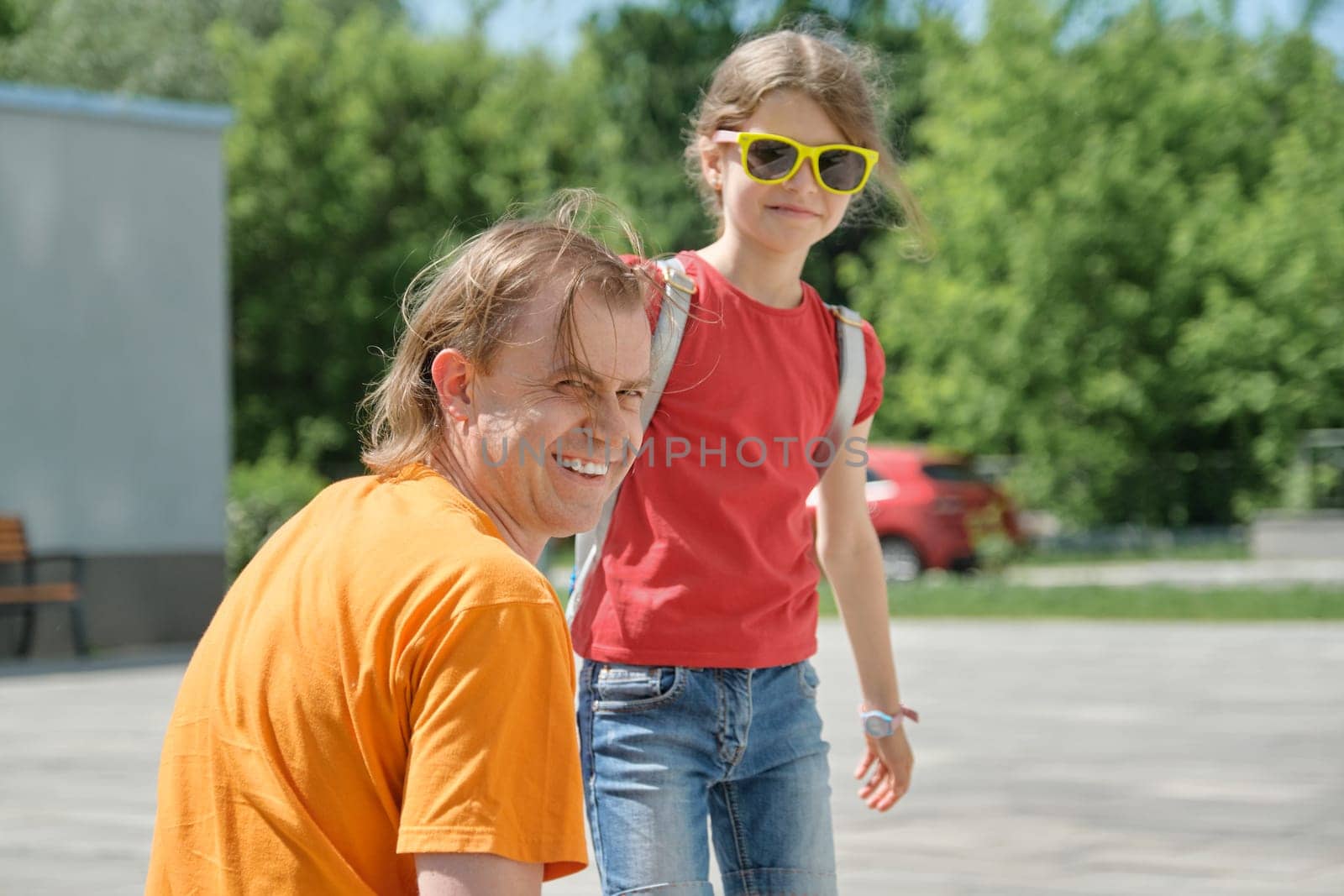 Outdoor summer portrait of father and daughter, happy smiling dad with child.