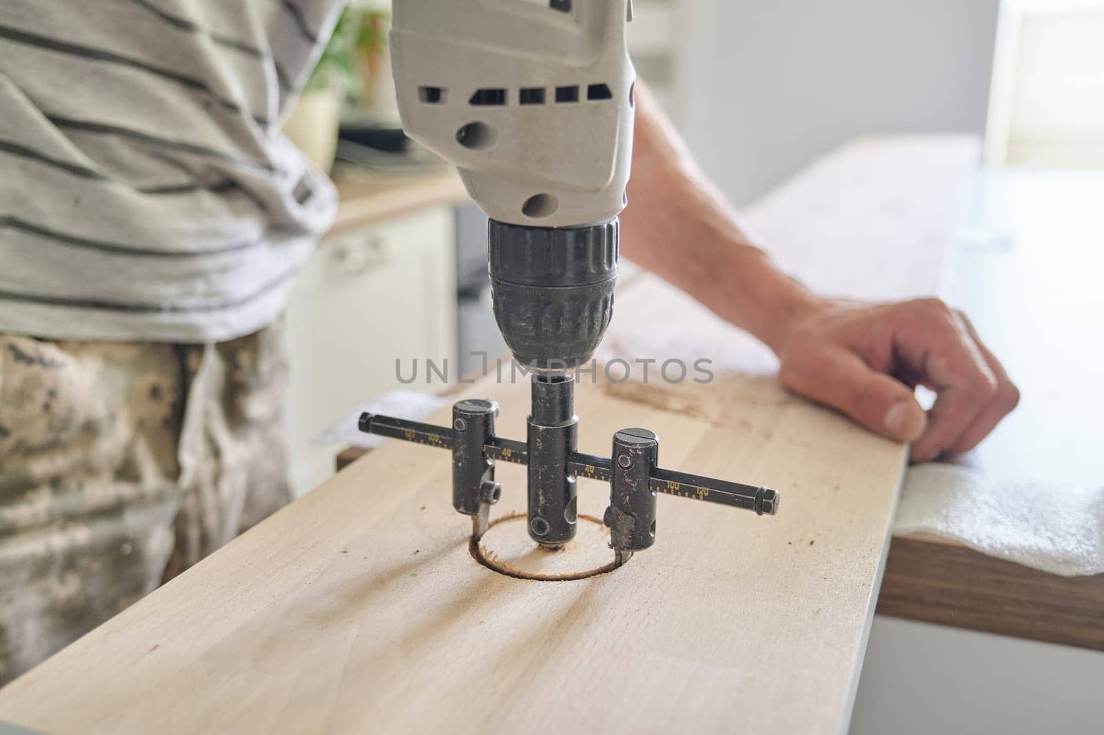 Close-up of carpenters hand using professional woodworking electric tools by VH-studio