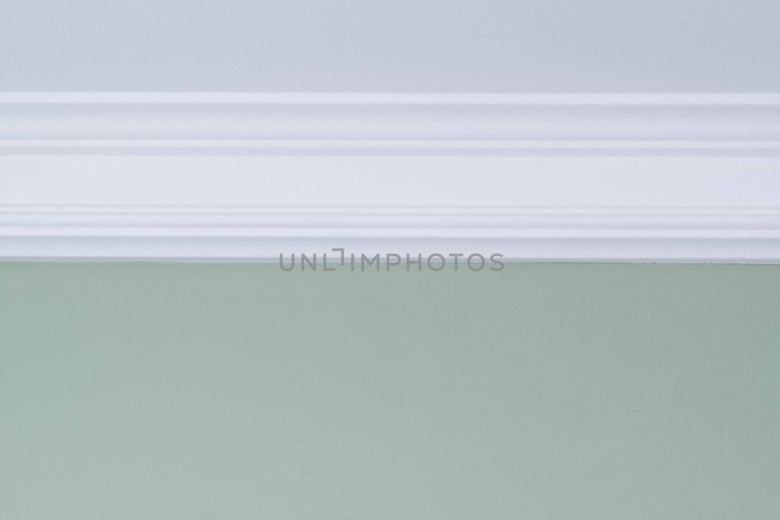 White ceiling molding, green painted wall. Interior details close-up by VH-studio