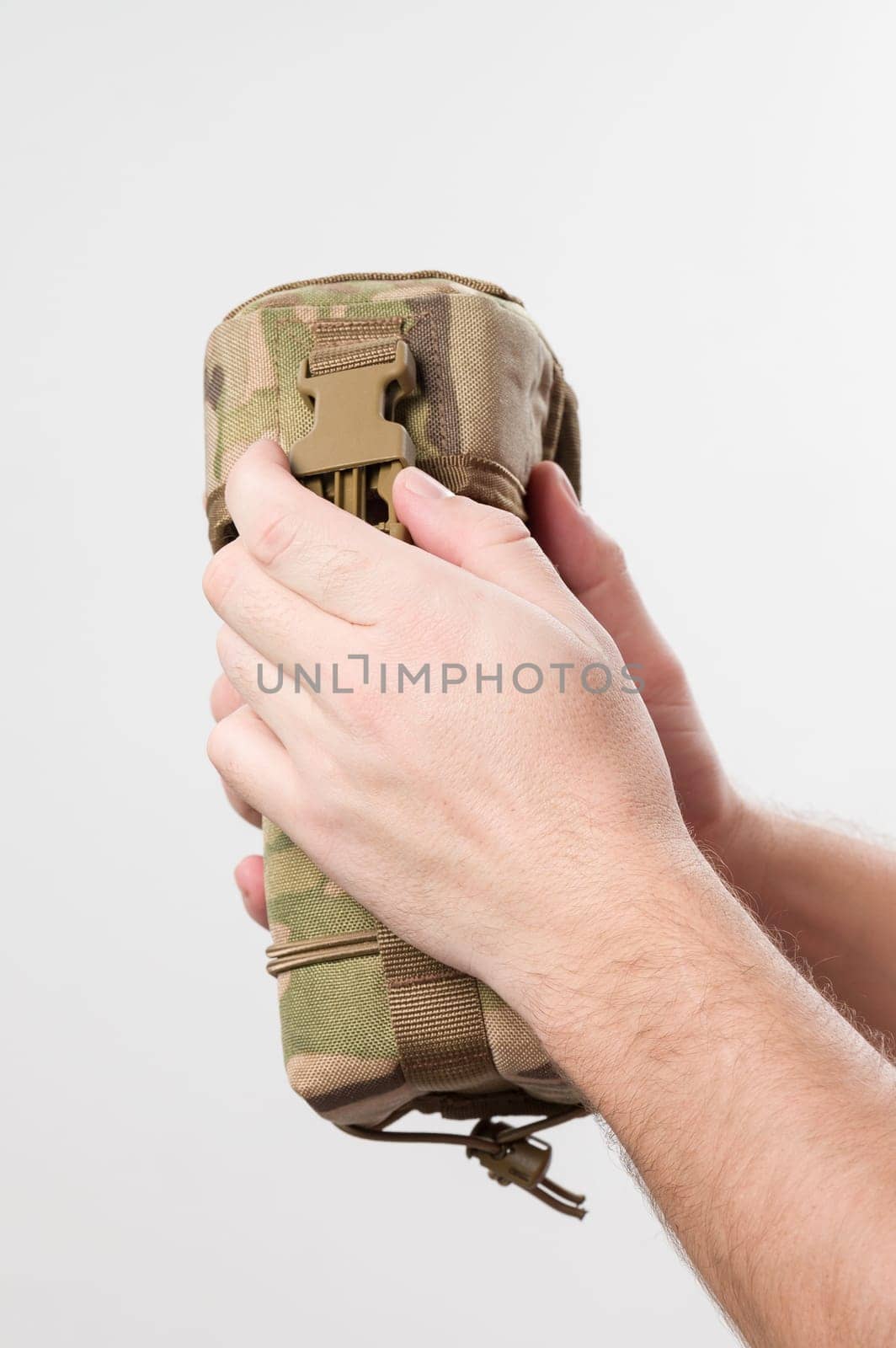 Man holding protective cover for monocular, military pixelated fabric, case isolated on white background.