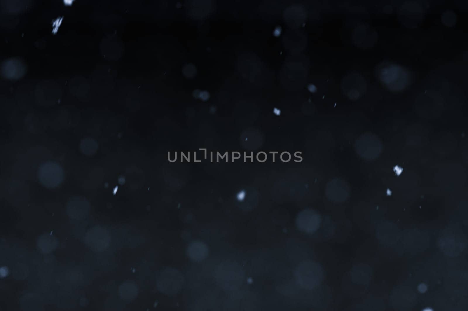Falling snowflakes on night sky background, isolated for post production and overlay in graphic editor. Bokeh of white snow on a black background.