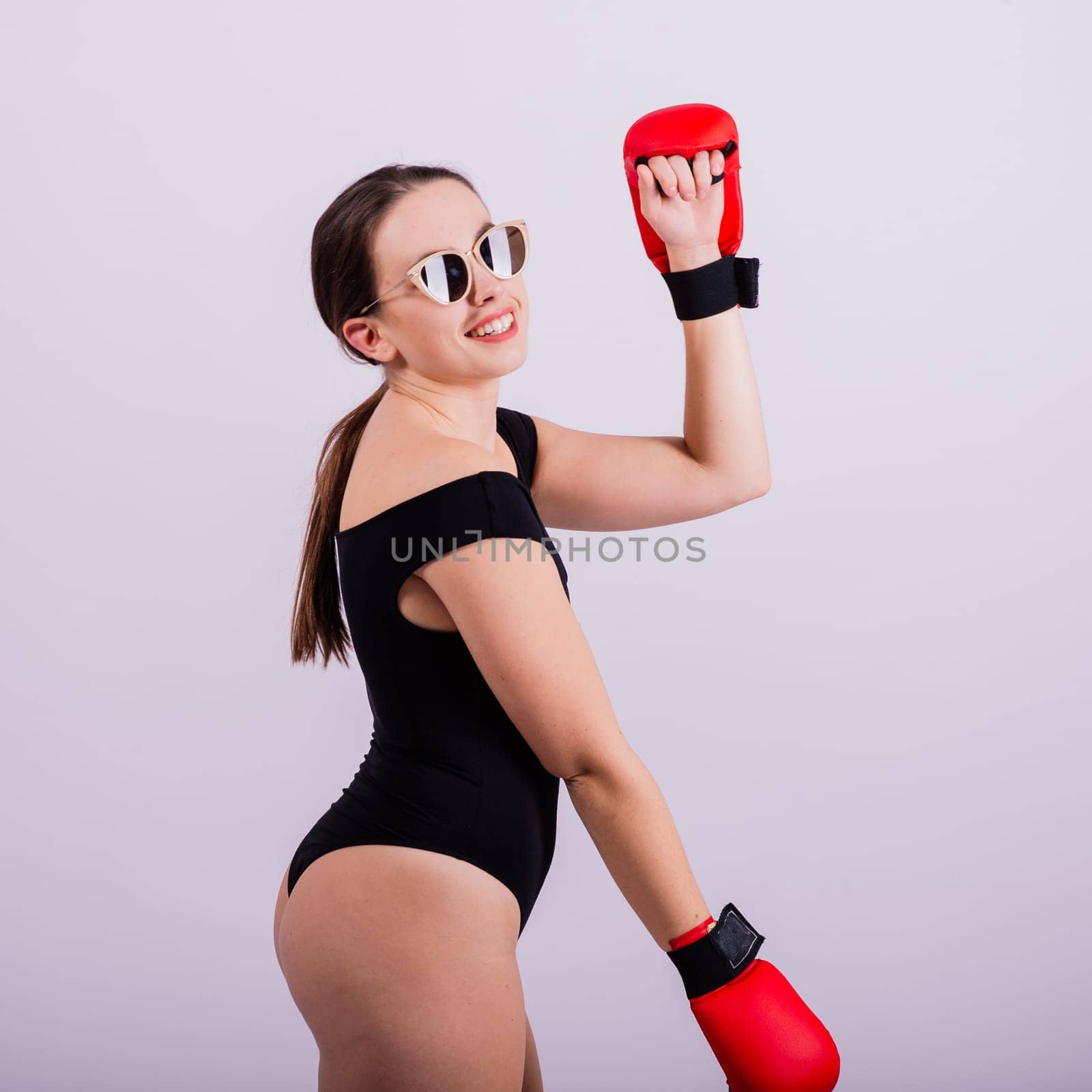 Studio portrait of a boxer female in bodysuit with gloves red