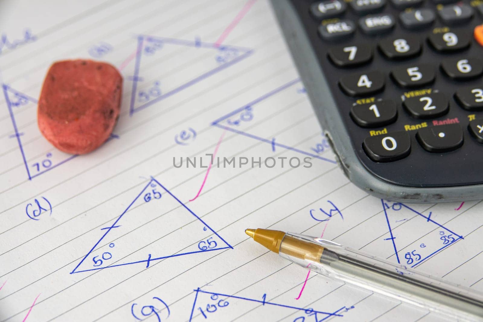 A Child's Math (Geometry) Homework Or Exam, With Calculator, Pen And Eraser