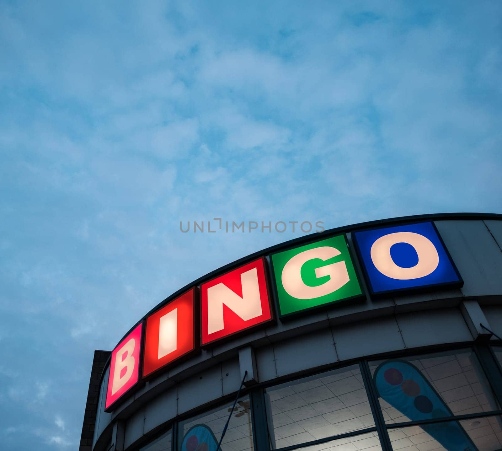A Sign For A Bingo Hall Against A Cloudy Sky In A British Town, With Copy Space