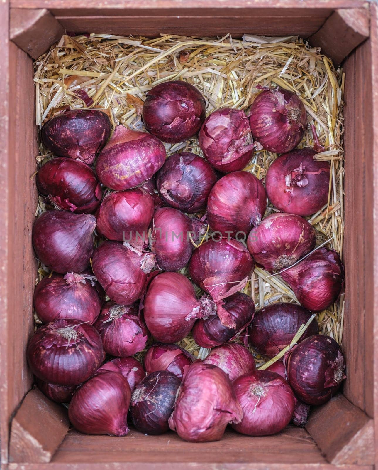 A Box Of Organic Red Onions At A Market