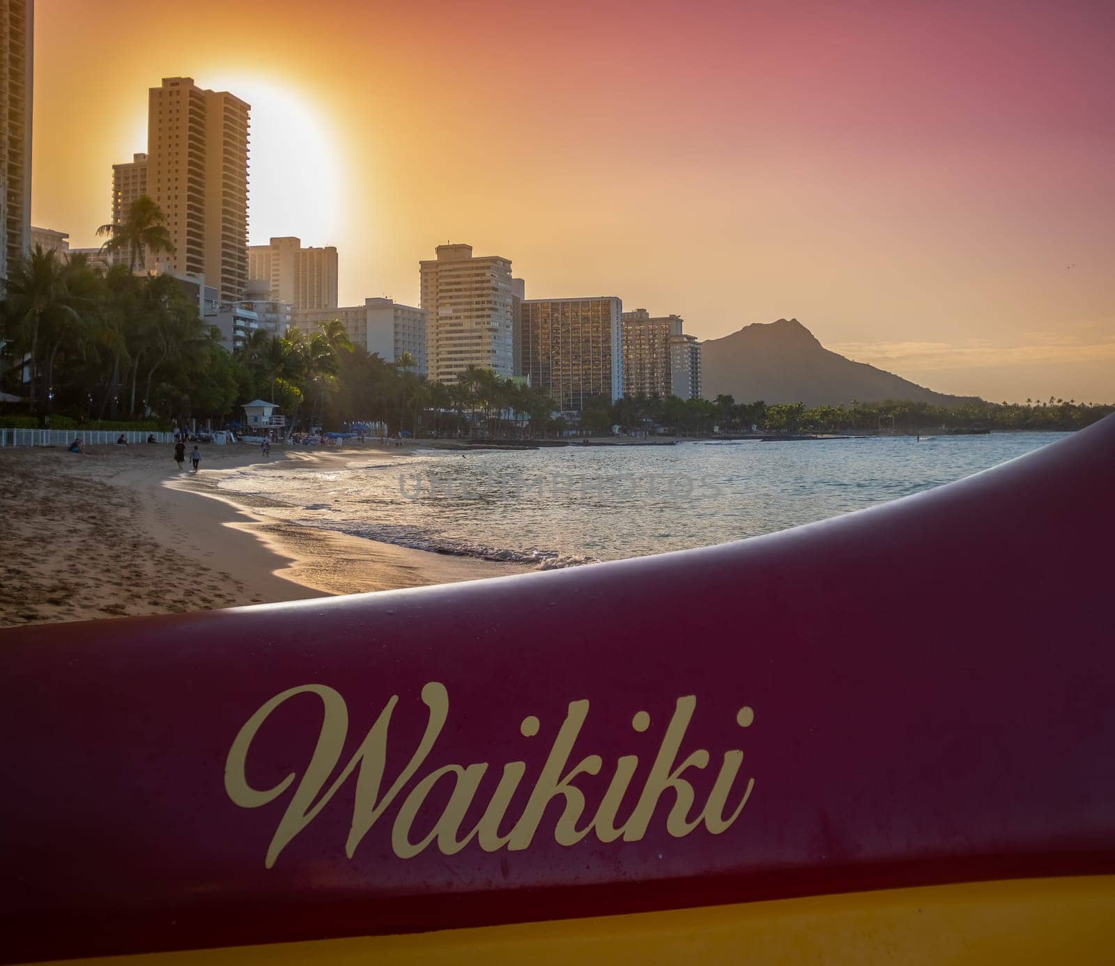 A Traditional Hawaiian Outrigger Canoe On Waikiki Beach At Sunset