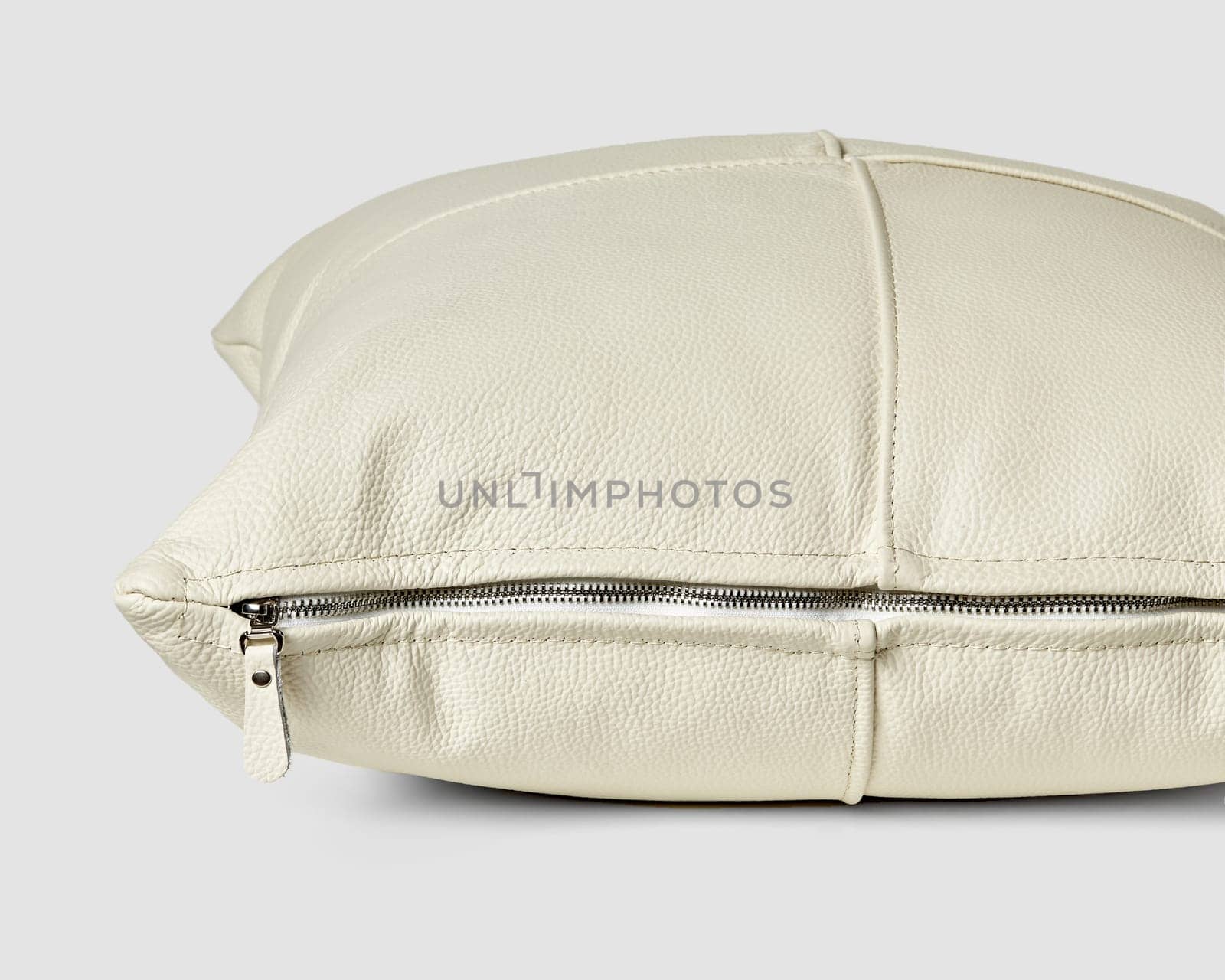 Closeup of handcrafted neatly stitched white leather sofa pillow with zipper by nazarovsergey