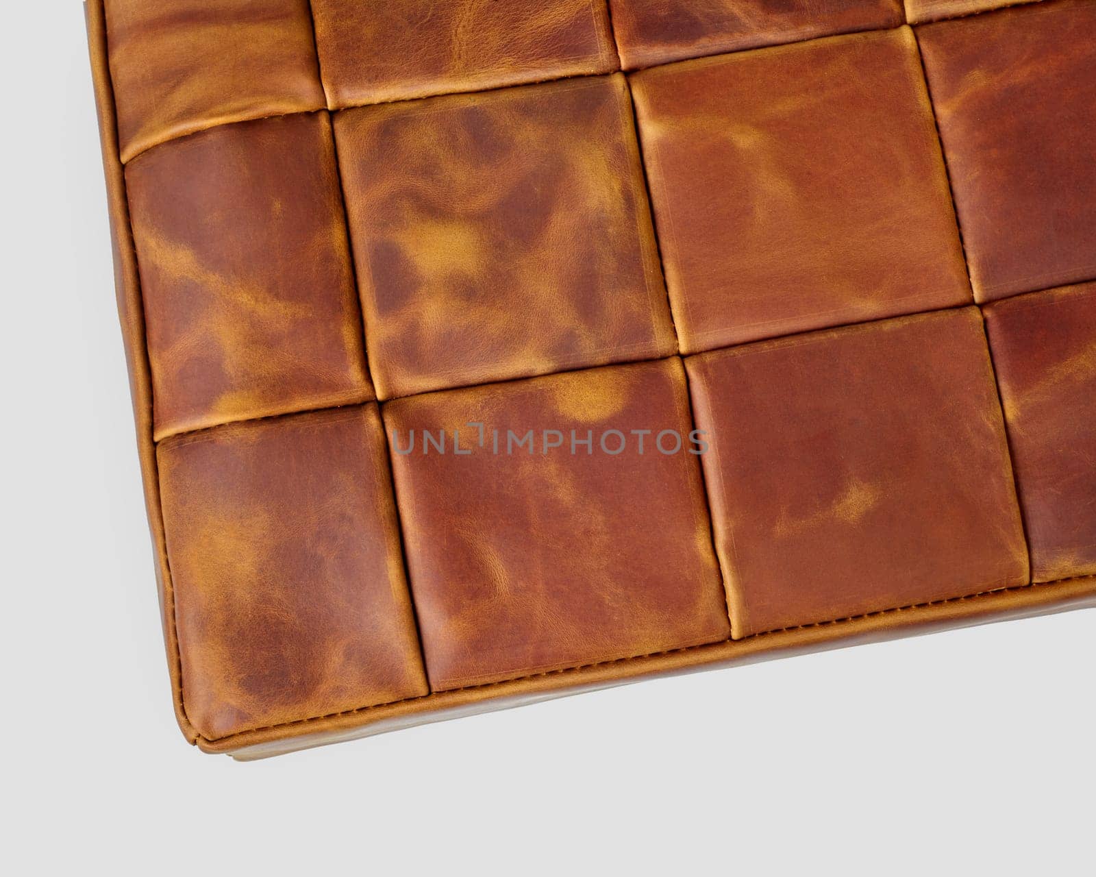 Closeup of soft meditation cushion for knee and leg comfort made from brown genuine leather patches. Handmade accessory for interior design