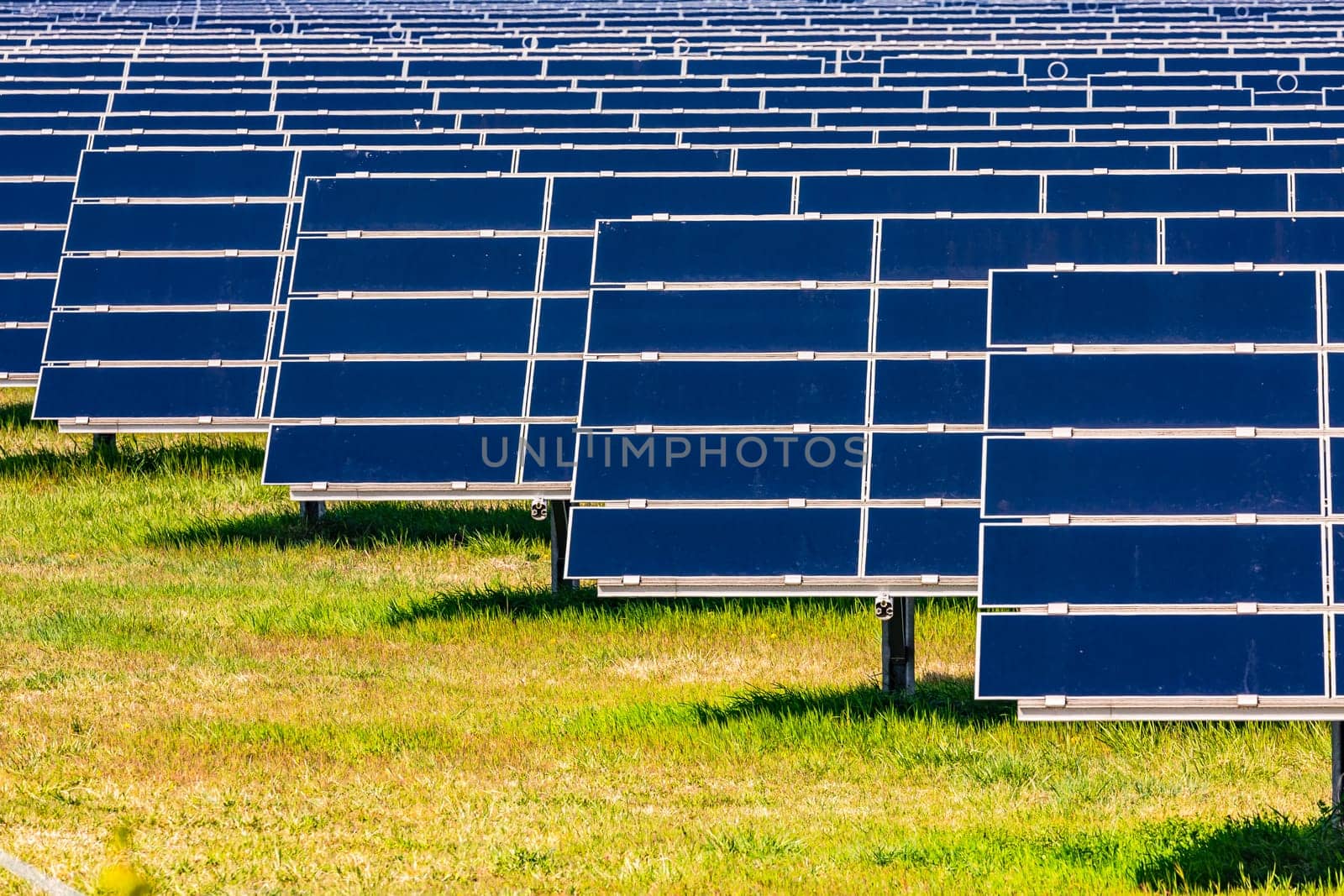 Solar panels of a PV system on a rural field for renewable energy generation by astrosoft