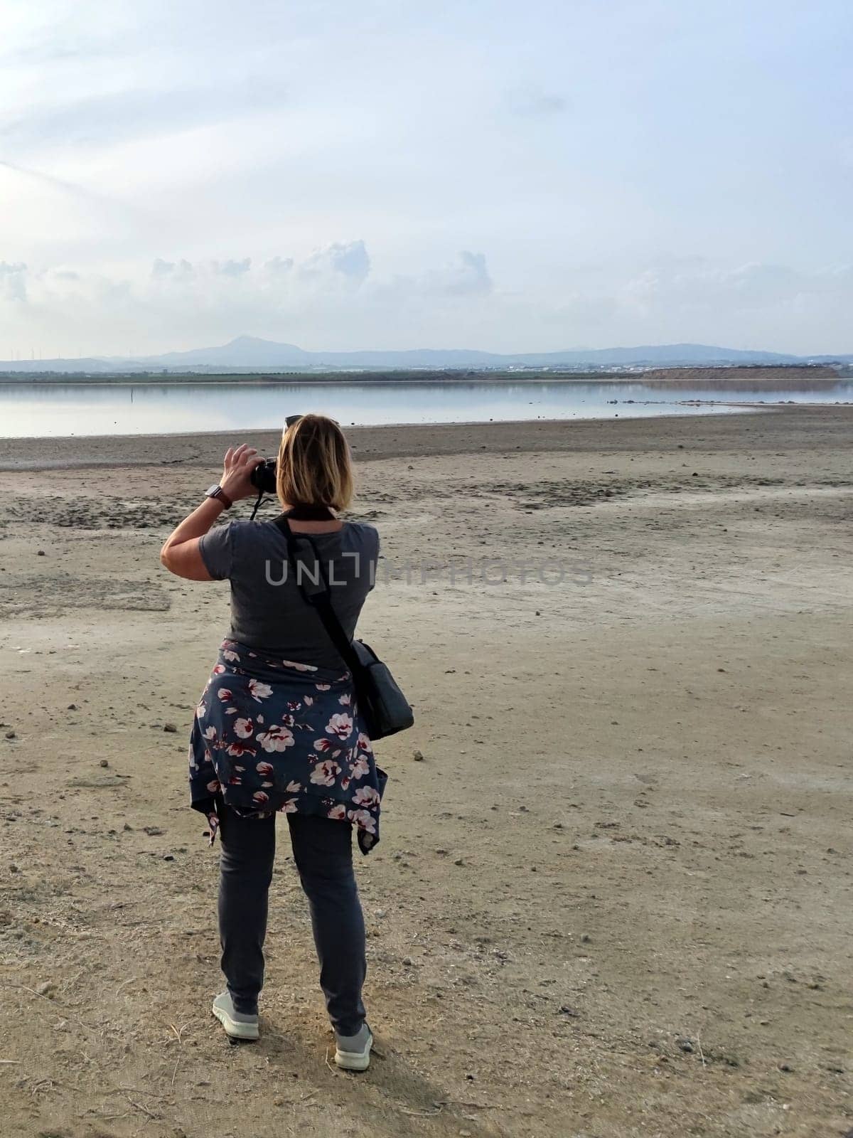 woman traveler taking pictures of nature, back view