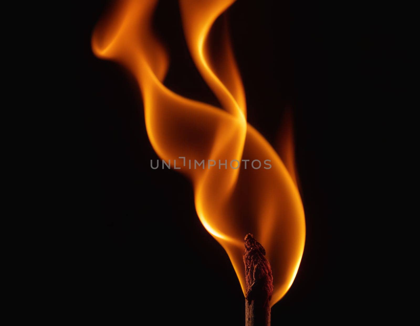 A close-up view of dynamic and intense flames in various shades of orange, yellow, and red, creating a contrast with the dark background and conveying a sense of heat and energy