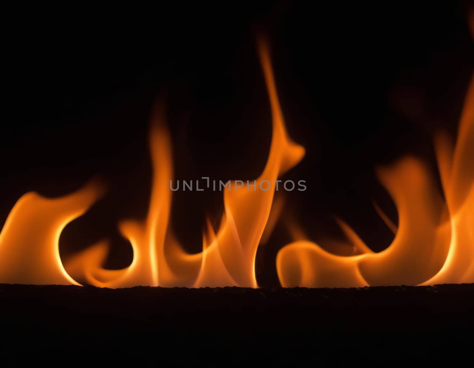 A close-up view of dynamic and intense flames in various shades of orange, yellow, and red, creating a contrast with the dark background and conveying a sense of heat and energy