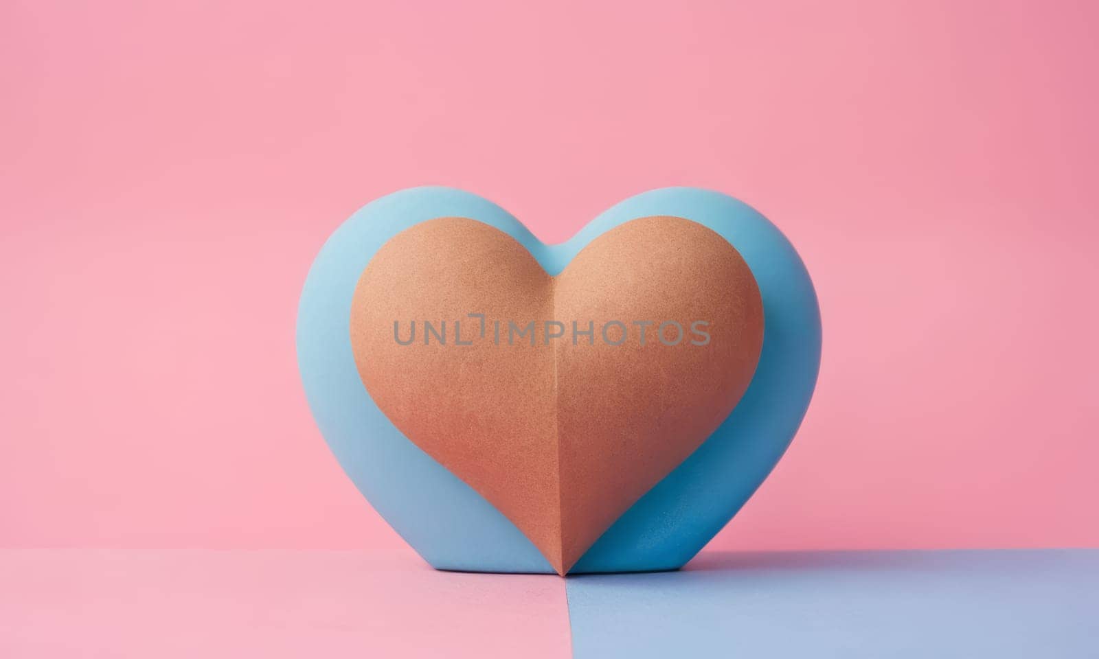 A textured heart shape stands prominently against a dual-tone background. The soft texture of the heart contrasts beautifully with the smooth blue and pink backdrop. Ideal for themes of love and romance.