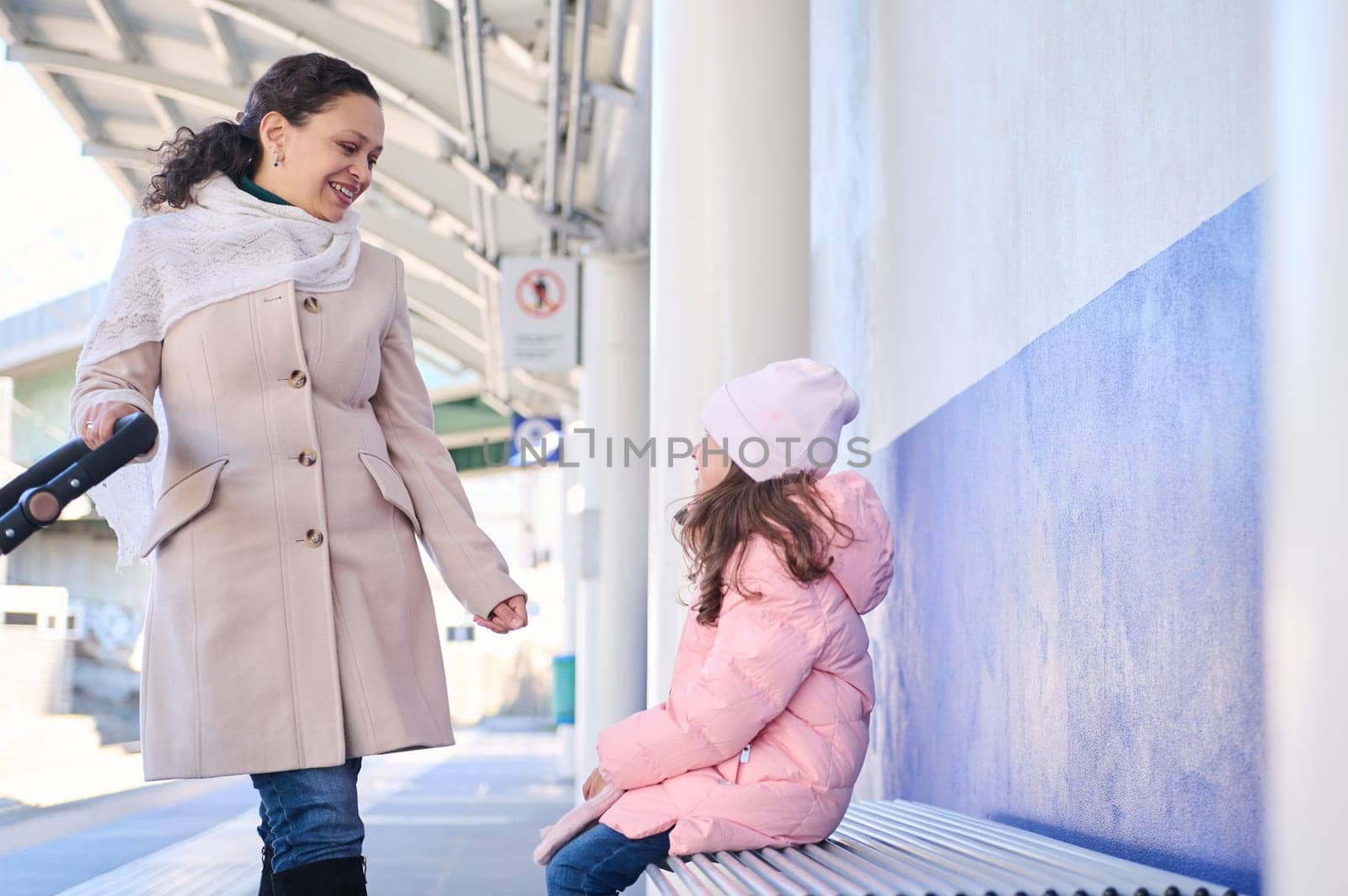 Mother and daughter waiting high-speed train in the train station by artgf