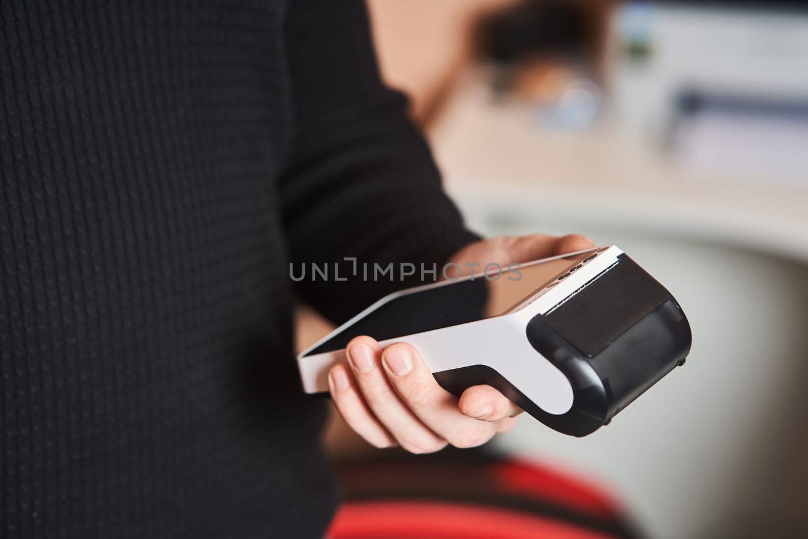 Bank terminal for contactless payment. Acquiring. Young man holds a terminal in his hands.