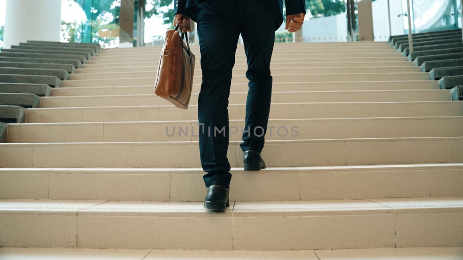 Closeup of business man leg go up the stairs. Successful man going up the stairs while explore a new thing. Traveling, getting a promotion, finding a new job, increasing skill. Back view. Exultant.