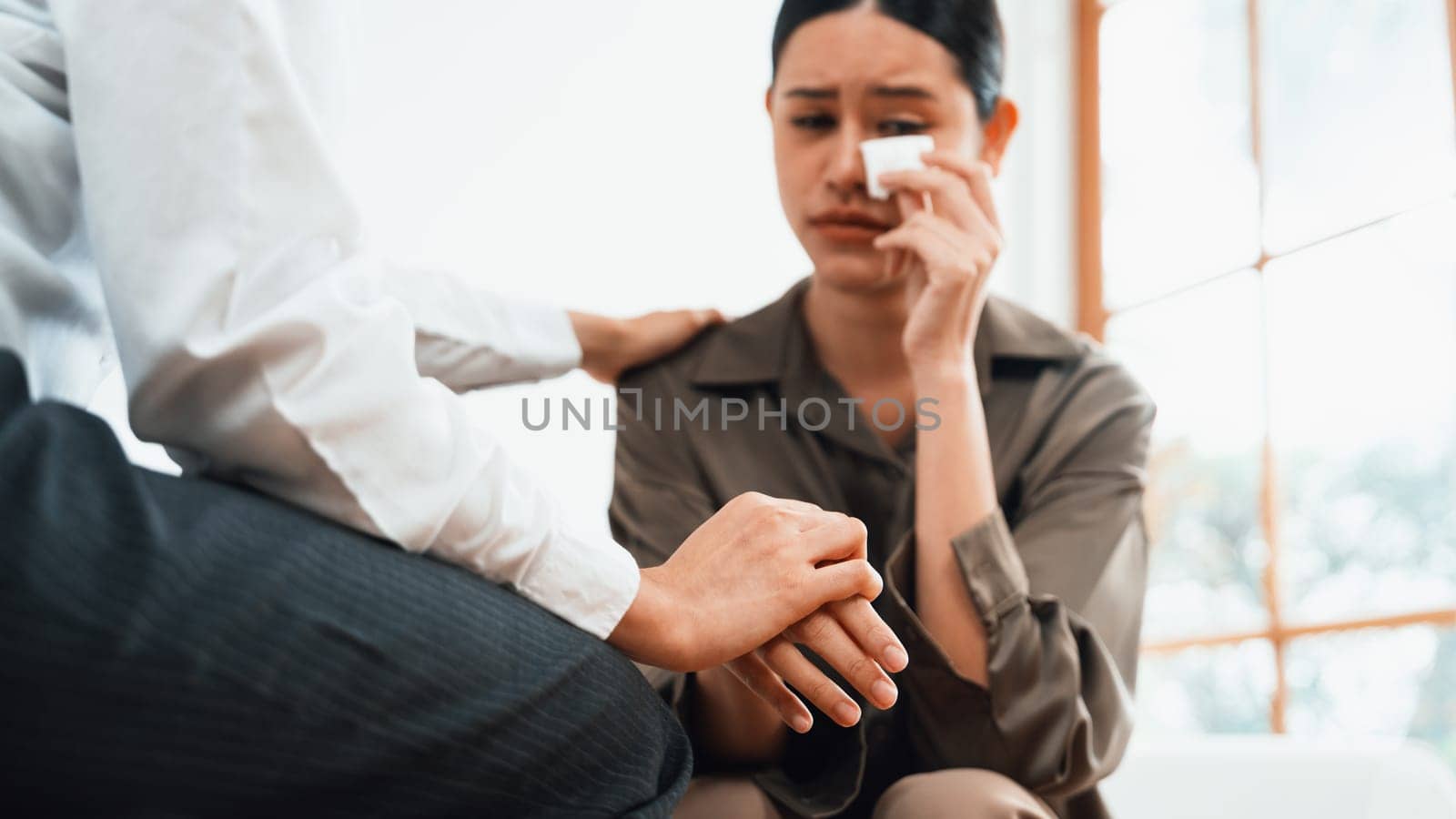 Sad PTSD woman patient in uttermost therapy for mental health with psychologist, depression or grief after life failure. Frustrated trauma young woman talking to a psychologist about emotion in clinic