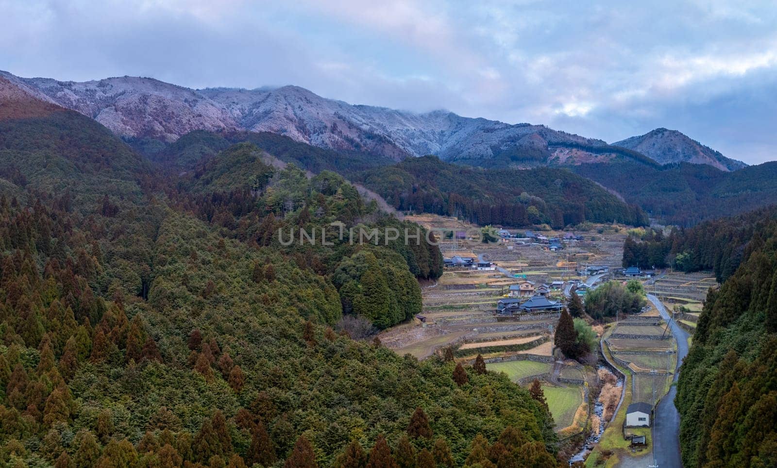 Aerial view of traditional farming village by snow covered mountains of Japan by Osaze