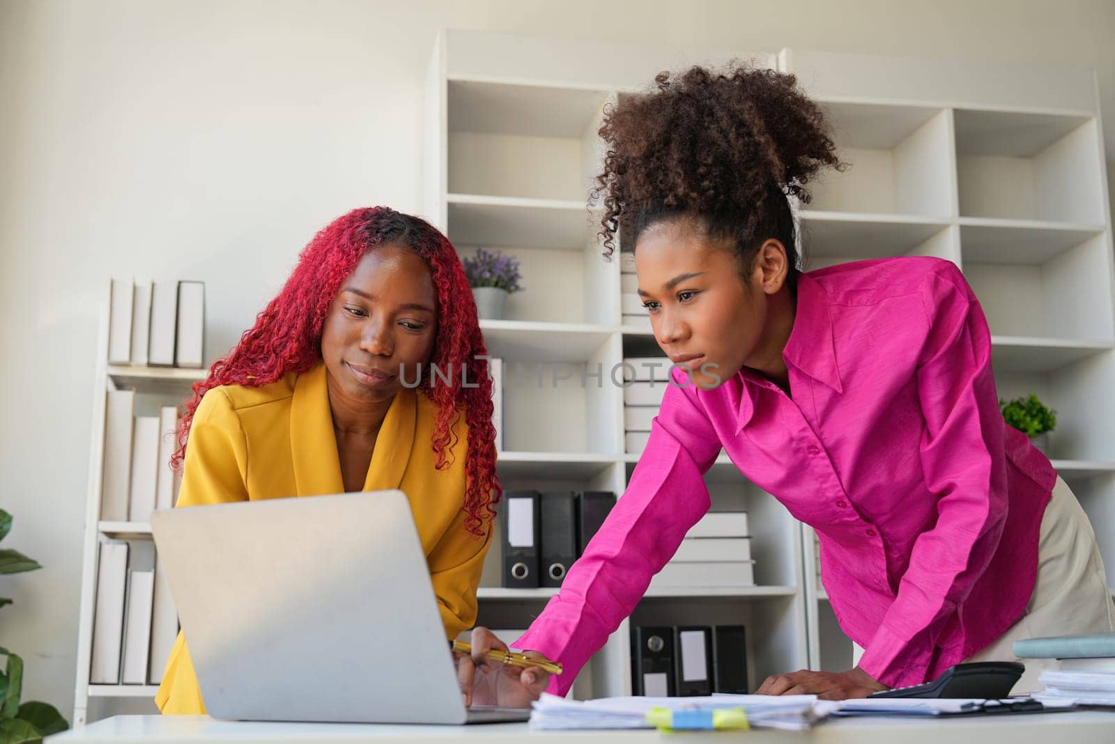 Two businesswoman African American working together using laptop and talking about a business project. team of females executive meeting work in office.