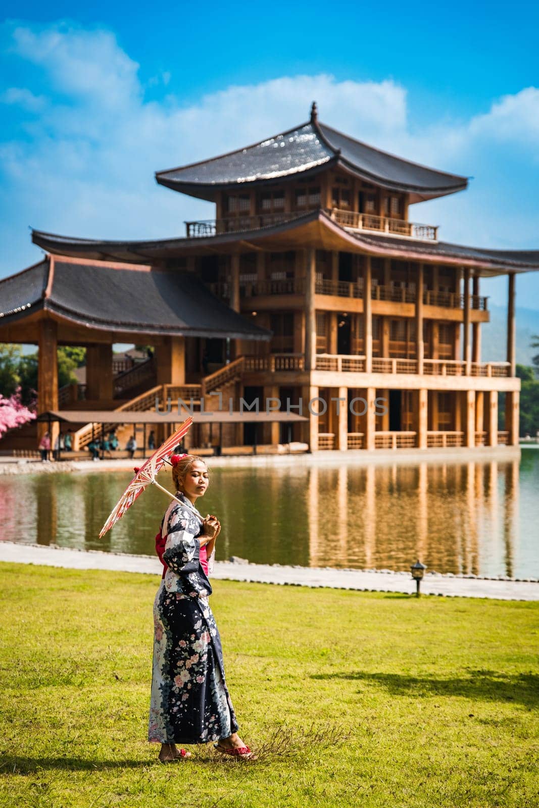 Asian girl in kimono and umbrella in Japanese theme park Hinoki Land in Chai Prakan District, Chiang Mai