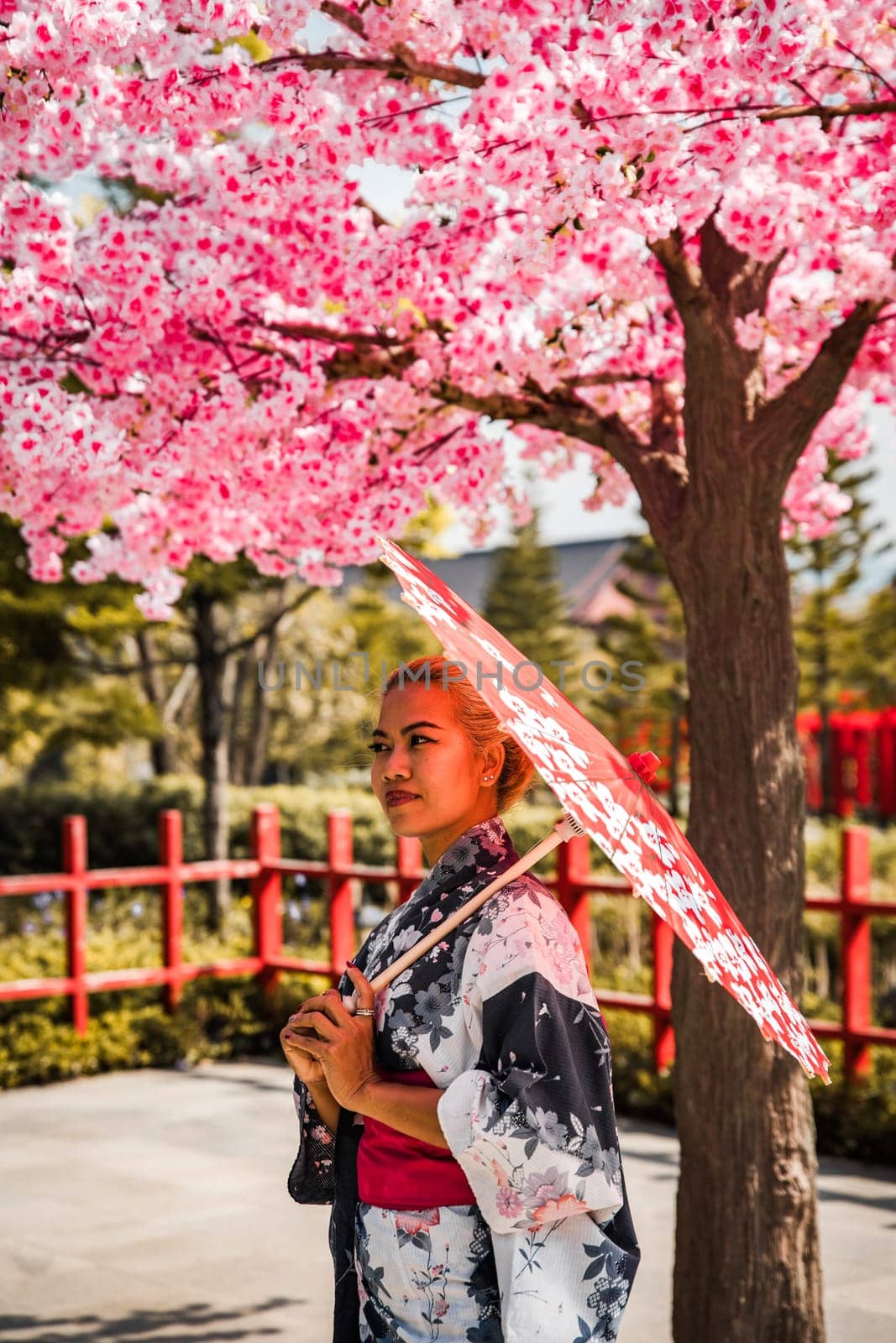 Asian girl in kimono and umbrella in Japanese theme park Hinoki Land in Chai Prakan District, Chiang Mai