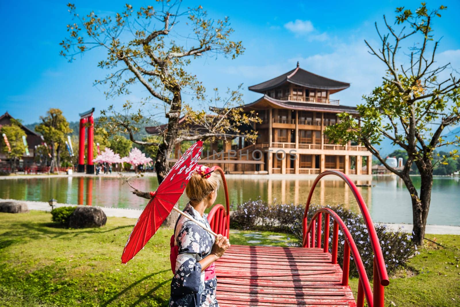 Asian girl in kimono and umbrella in Japanese theme park Hinoki Land in Chai Prakan District, Chiang Mai