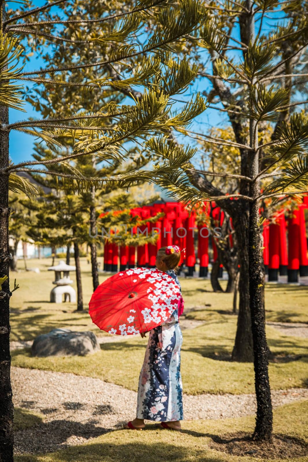 Asian girl in kimono and umbrella in Japanese theme park Hinoki Land in Chai Prakan District, Chiang Mai