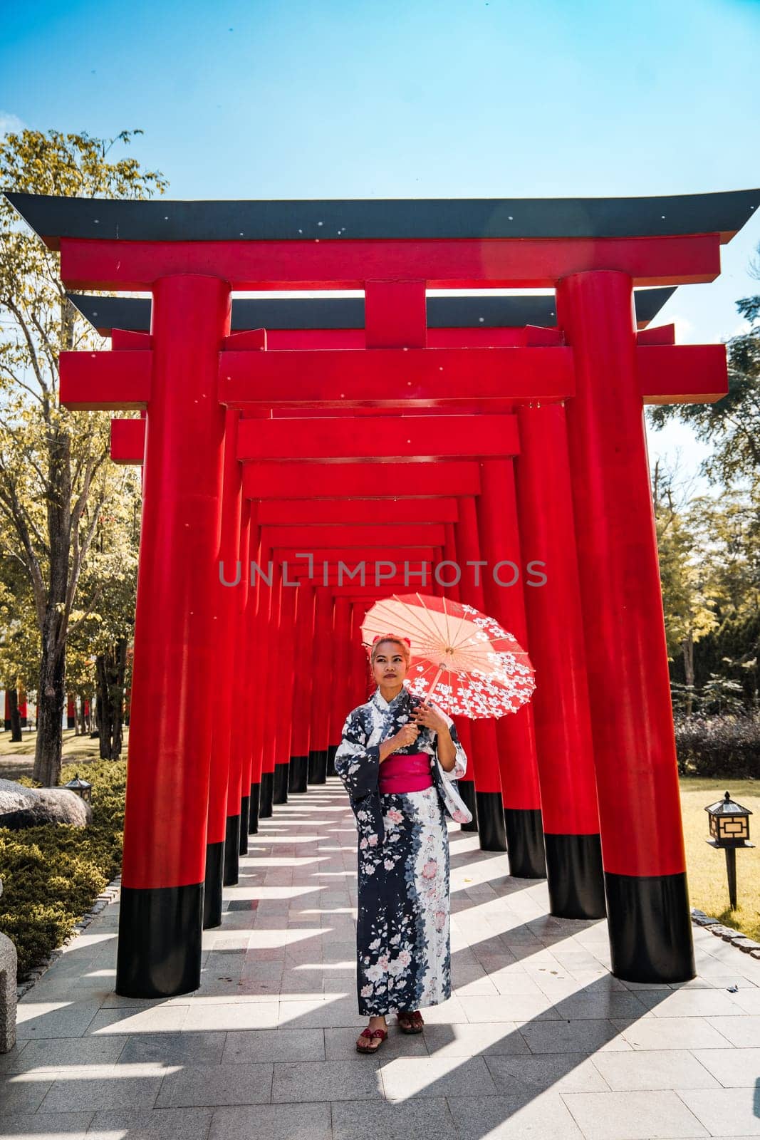 Asian girl in kimono and umbrella in Japanese theme park Hinoki Land in Chai Prakan District, Chiang Mai