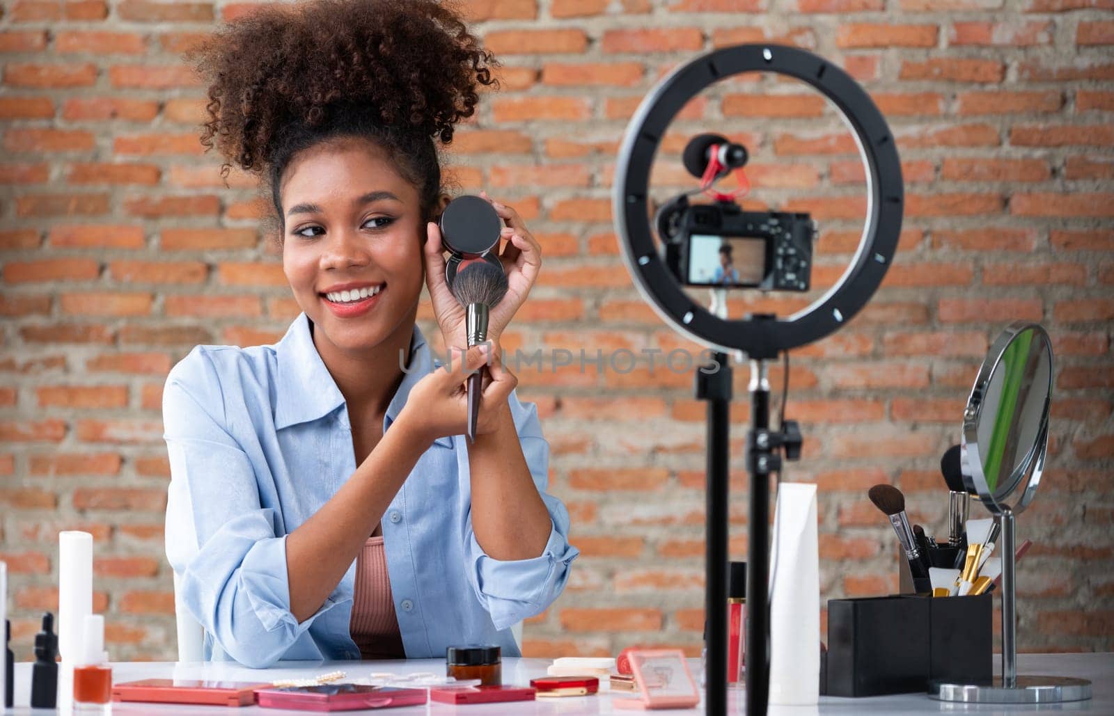 Woman influencer shoot live streaming vlog video review makeup crucial social media or blog. Happy young girl with cosmetics studio lighting for marketing recording session broadcasting online.