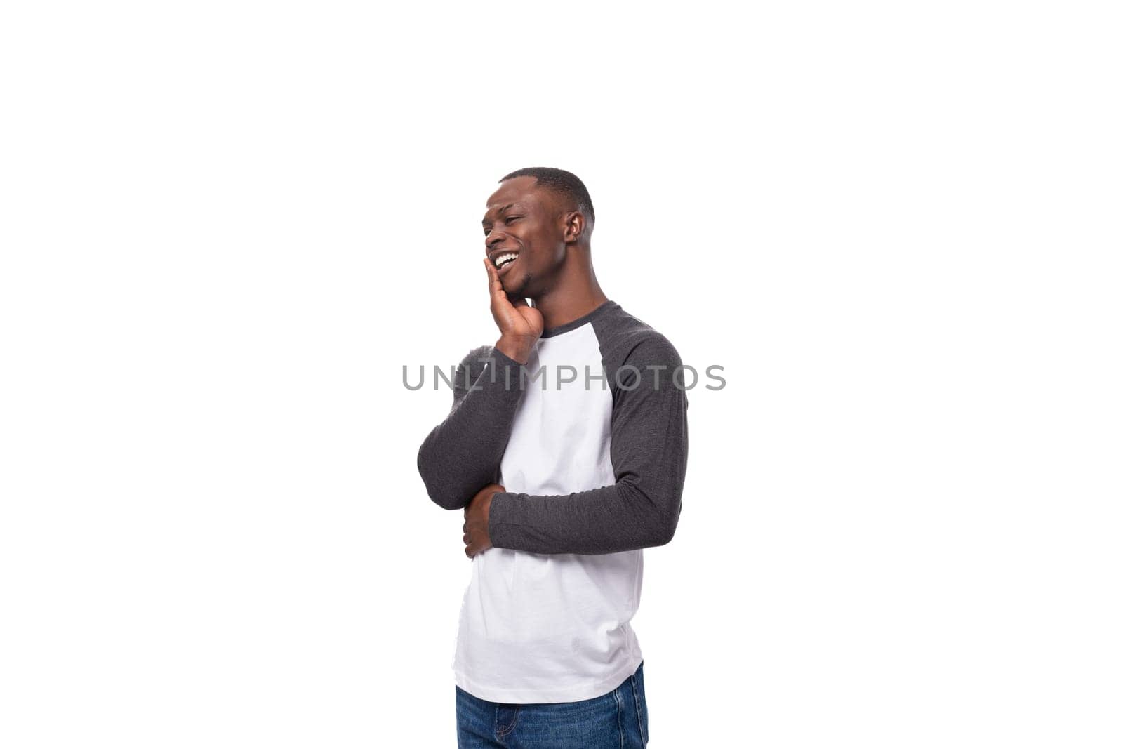 young happy african guy dressed in a sweatshirt feels joy.