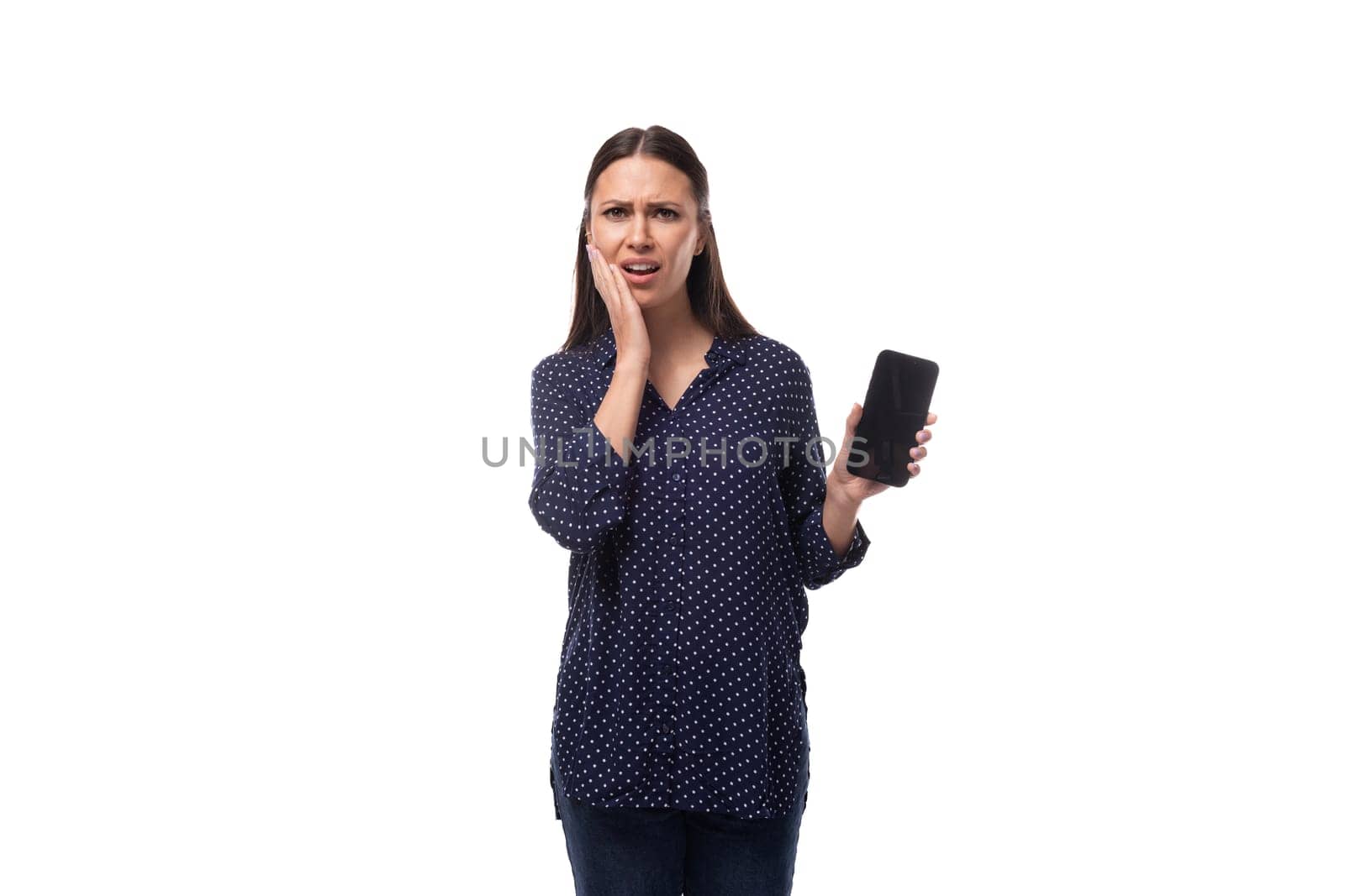 young sad brunette business woman dressed in a blue shirt shows a smartphone with a mockup by TRMK