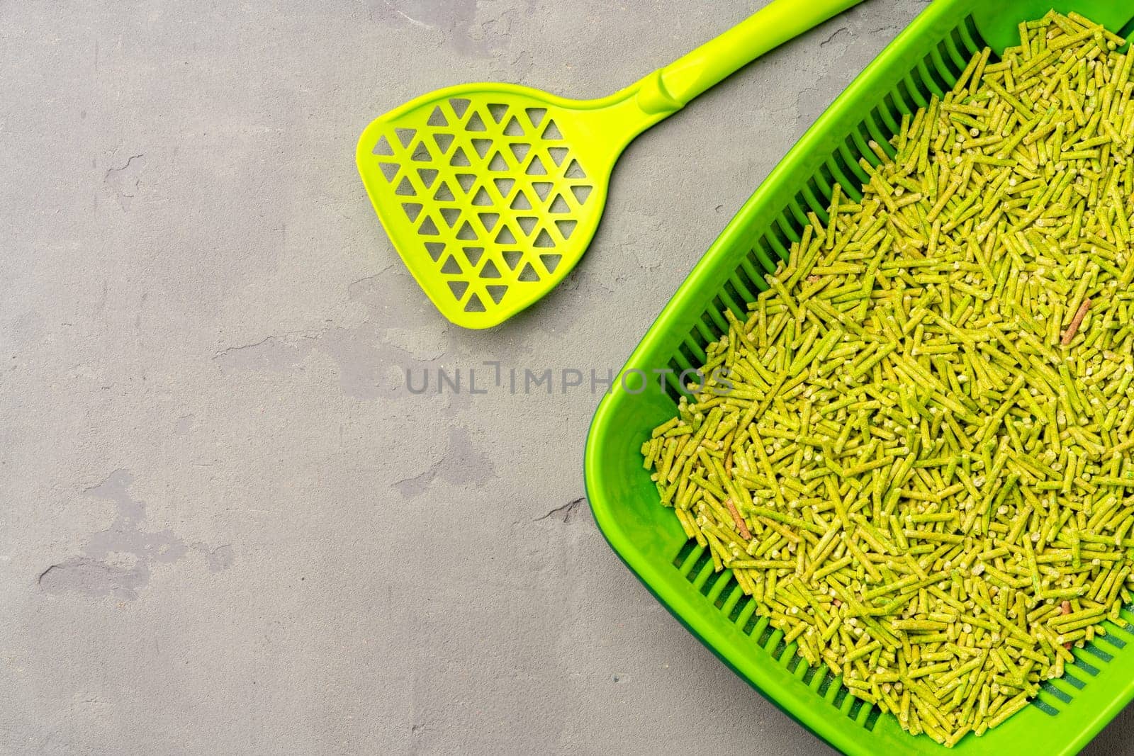 Pet litter tray with wooden filler on gray background close up